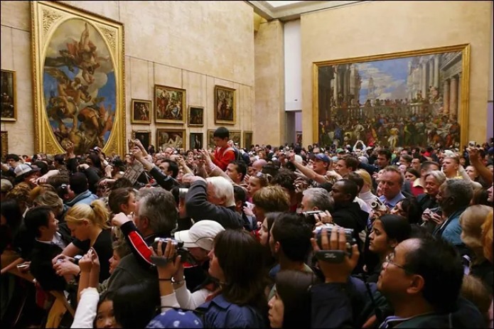 Скопление людей возле экспонатов Лувра - фото